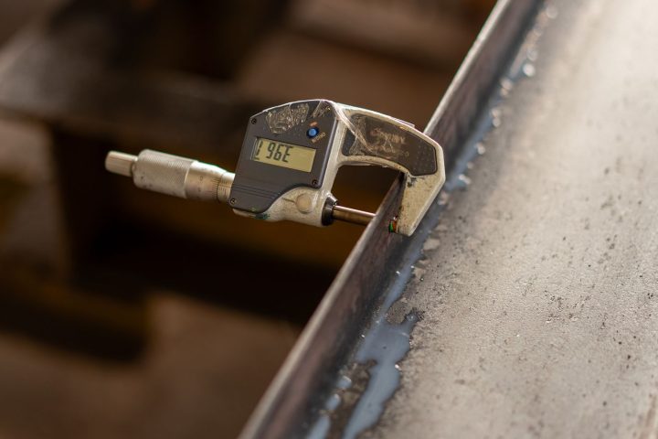 Digital caliper measuring a machined metal part