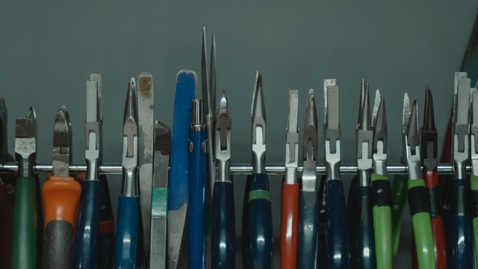 Pliers and hand tools hanging neatly on a wall rack
