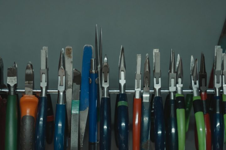 Pliers and hand tools hanging neatly on a wall rack